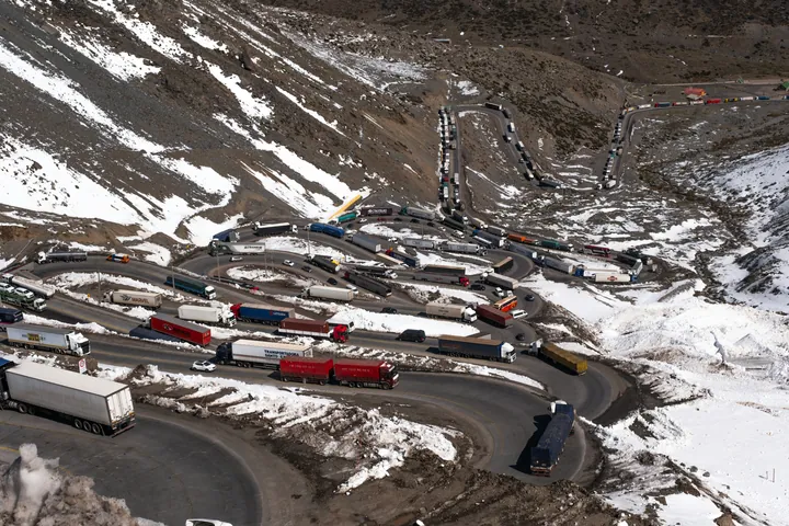 Camiones en las curvas de una carretera de montaña con nieve.