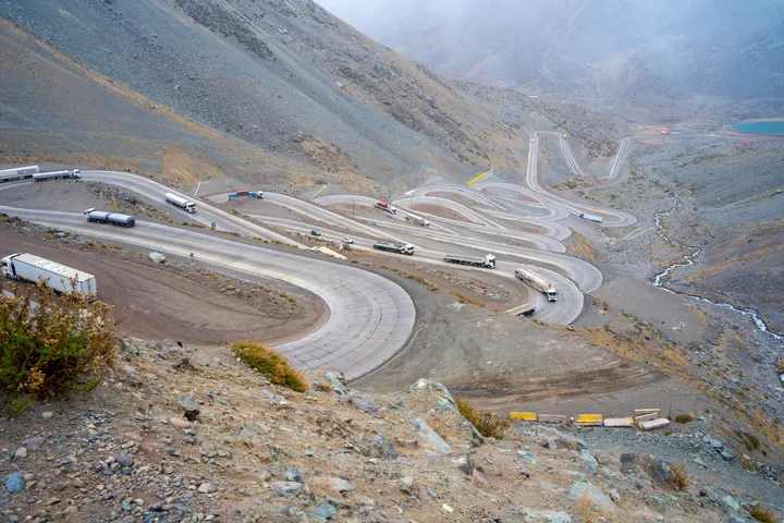 Camiones circulando por un camino de montaña con curvas.