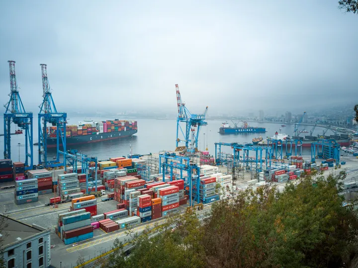 Grúas y contenedores de un terminal portuario vistos desde la ciudad.